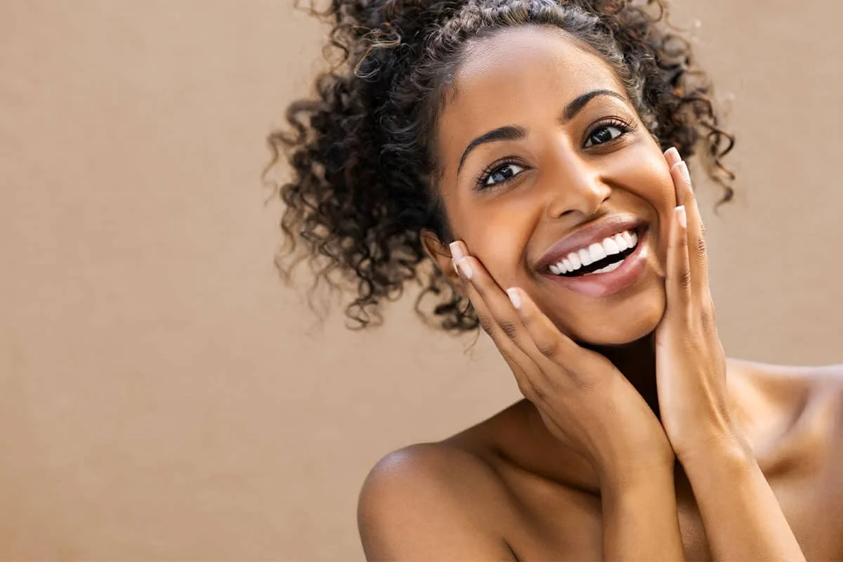 Woman smiling and touching her face